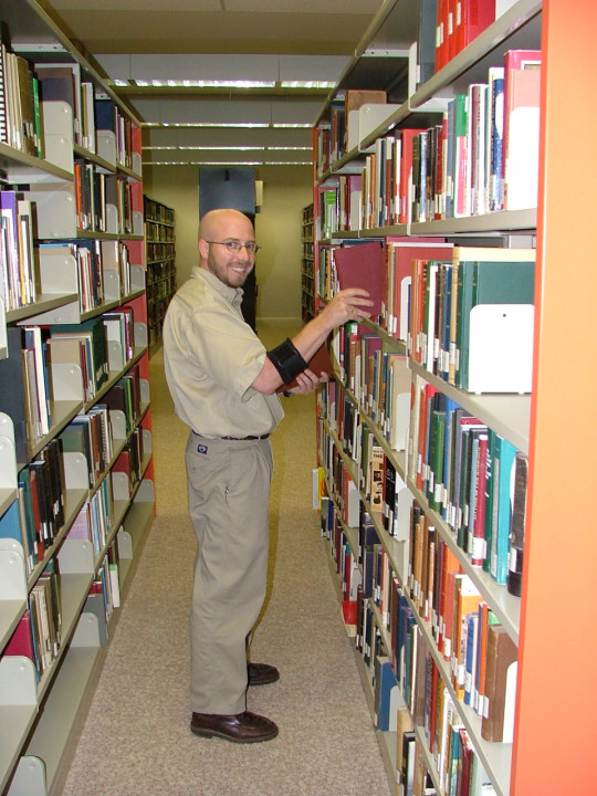 gentlemen searching books off bookshelf