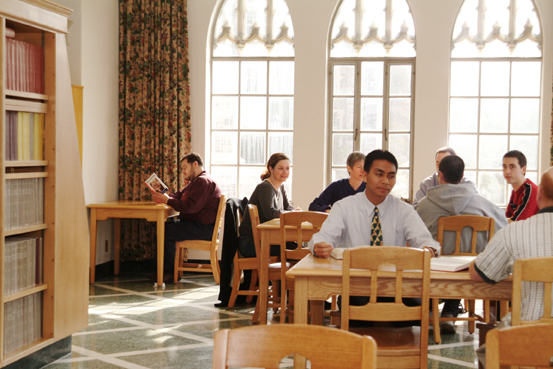 Many busy people sitting at desks.